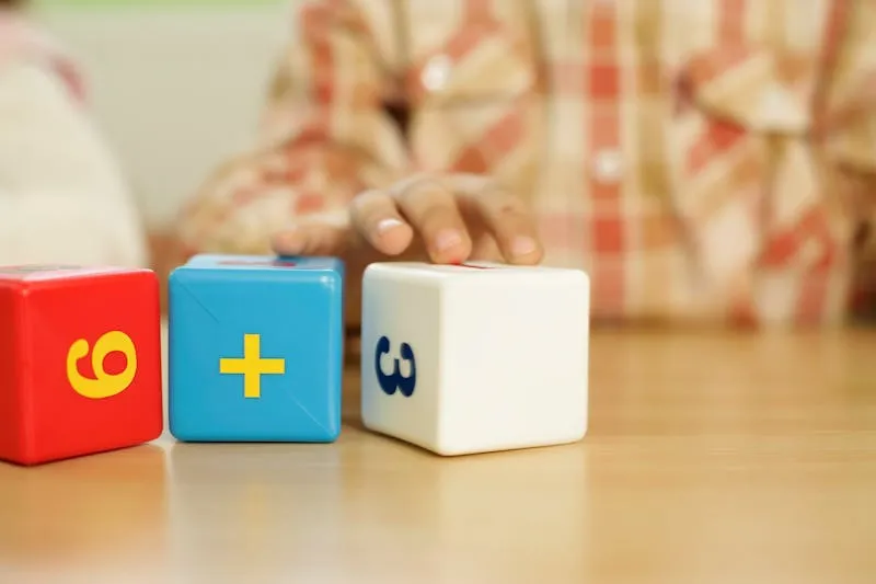 Child's hand touching educational math blocks